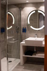 a bathroom with a shower and a sink and a mirror at Radisson Blu Hotel Bordeaux in Bordeaux