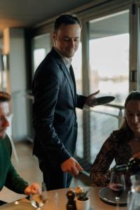 a man in a suit holding a knife at a table at Radisson Blu Hotel Bordeaux in Bordeaux