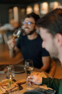 a man sitting at a table with a glass of wine at Radisson Blu Hotel Bordeaux in Bordeaux