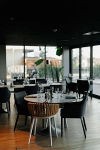 a dining room with tables and chairs and windows at Radisson Blu Hotel Bordeaux in Bordeaux