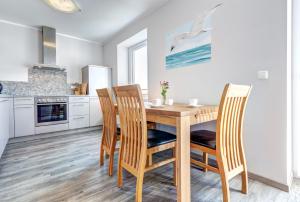 a kitchen with a wooden table and chairs at Peenemünde, Seglerhafen_ST_Jolle 16 in Peenemünde +5 photos