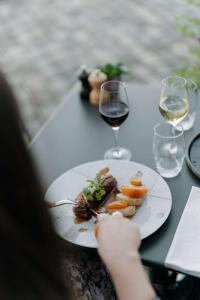 a person holding a plate of food and a glass of wine at Radisson Blu Hotel Bordeaux in Bordeaux