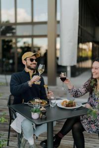 a man and woman sitting at a table with glasses of wine at Radisson Blu Hotel Bordeaux in Bordeaux