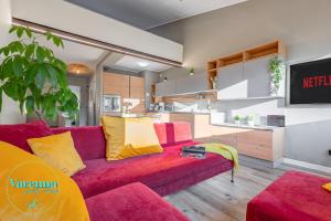 a living room with a red couch and a kitchen at Varenna Guest House in Varenna