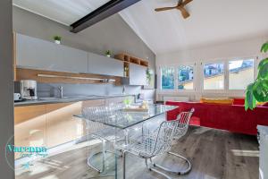 a kitchen with a glass table and a red couch at Varenna Guest House in Varenna