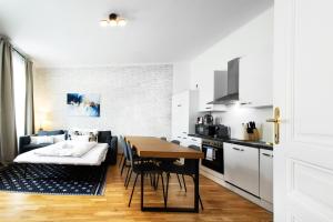 a kitchen and dining room with a table and a couch at OrestaLiving - BrigittineurLände in Vienna