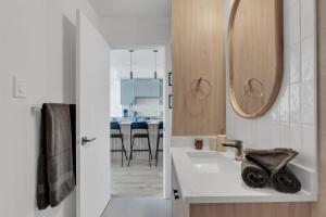a bathroom with a sink and a mirror at Bright Condo with Balcony & Free Parking in Calgary +20 photos