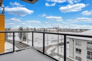 a balcony with a view of a snow covered street at Bright Condo with Balcony & Free Parking in Calgary