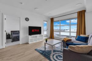a living room with a couch and a tv at Bright Condo with Balcony & Free Parking in Calgary