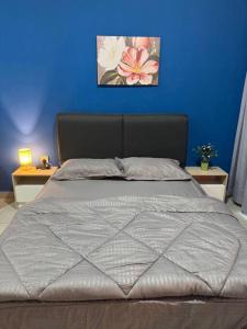 a bedroom with a bed with a blue wall at Alinea Suites Seksyen 14 in Shah Alam