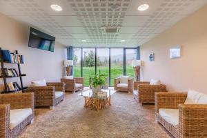 a waiting room with wicker chairs and a table at Appart’City Confort Vannes in Vannes