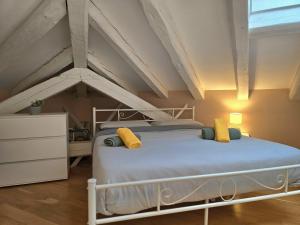 Un dormitorio con una cama blanca con almohadas amarillas. en Mohho suite, en Trieste