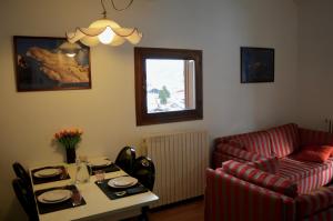 a living room with a couch and a table at Hostdomus - Casa Borgata in Borgata Sestriere