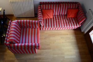 a red and white couch in a living room at Hostdomus - Casa Borgata in Borgata Sestriere