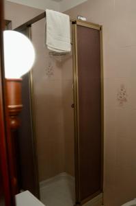 La salle de bains est pourvue d'une douche et d'une serviette accrochée au mur. dans l'établissement Hostdomus - Casa Borgata, à Borgata Sestriere