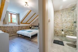 a bedroom with a bed and a bathroom at Villa Dovecote with Private Sauna, Jacuzzi & Gym in Ston