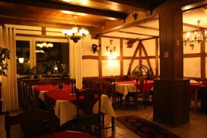 a restaurant with tables and chairs with red table cloth at Landgasthof Schlotmann in Welver