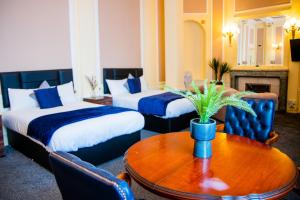 a hotel room with two beds and a table at Adelphi Hotel in Liverpool