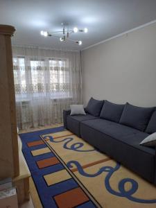 un soggiorno con divano blu e tappeto di Конаев Капшагай 2-х комнатная квартира a Kapchagay