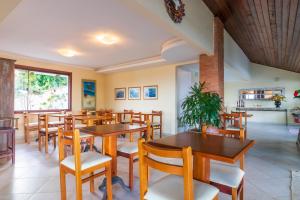 a restaurant with wooden tables and chairs at La Proeza Pousada in Búzios +32 photos