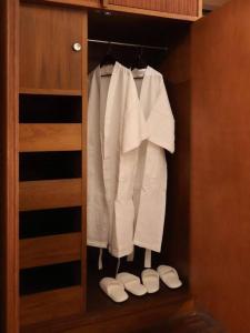 een kast met witte kleren en schoenen erin bij Timber & Terrace in Bangkok