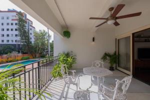 een balkon met stoelen, een tafel en een plafondventilator bij Timber & Terrace in Bangkok