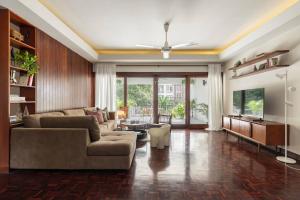 een woonkamer met een bank en een tafel bij Timber & Terrace in Bangkok