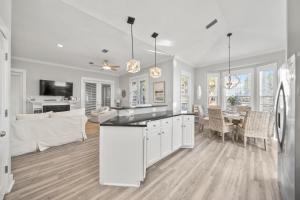 a kitchen and dining room with white cabinets and a table at Ventana Breeze in Santa Rosa Beach