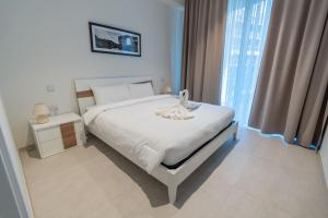 a bedroom with a white bed and a window at Exquisite Residence in Mercury Towers in St. Julianʼs +29 photos