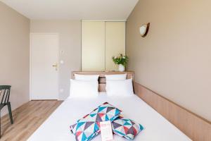 Un pat sau paturi într-o cameră la Appart'City Confort Nantes Cité des Congrès
