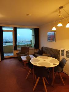 a living room with a table and chairs and a couch at Apartment Morgengruß - Pool & Sauna in Hohegeiß