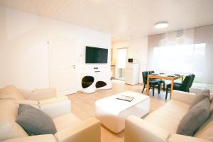 Ferienhaus Pelikanstr 129 Ostermann Bungalow 5 في نورديش: غرفة معيشة بها أريكة وطاولة