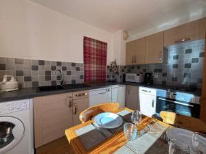 a kitchen with a wooden table with a tableablish at Résidence Atrey Clés Blanches in La Tania +10 photos