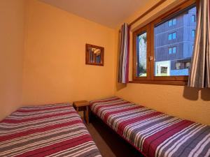 two beds in a room with a window at Résidence Atrey Clés Blanches in La Tania