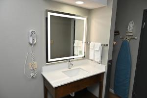 ein Badezimmer mit Waschbecken und Spiegel in der Unterkunft Super 8 by Wyndham Higginsville in Higginsville + 23 Fotos