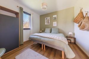 a bedroom with a bed and a window at Les 4 Saisons des Violonges - Vue montagne in Neussargues en Pinatelle