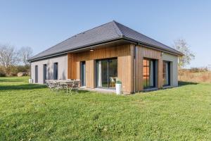a small house with a picnic table in a field at Les 4 Saisons des Violonges - Vue montagne in Neussargues en Pinatelle