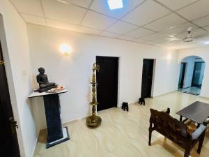 a room with a statue and a table and two cats at Lagoon House - Hiriketiya in Dickwella