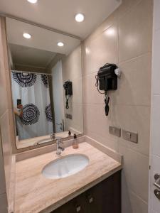 a bathroom with a sink and a large mirror at Departamento central Viña del Mar in Viña del Mar