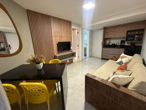 a living room and kitchen with a couch and a table at Jatiuca Suítes Resort FLAT in Maceió