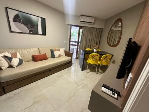 a living room with a couch and a table at Jatiuca Suítes Resort FLAT in Maceió +83 photos