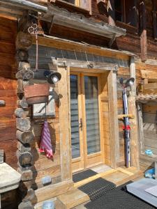 マニグードにあるAppartement Coeur De Chaletの丸太小屋の玄関