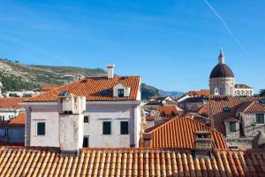 Blick auf eine Stadt mit Dächern und einem Turm in der Unterkunft Apartment Albidus A31 in Dubrovnik