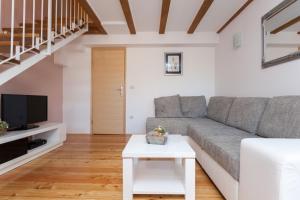 ein Wohnzimmer mit einem Sofa und einem TV in der Unterkunft Apartment Albidus A31 in Dubrovnik