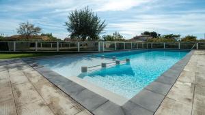 a large swimming pool with a bench in the middle at La Dune 29 - VILLA 4P9 in Valras-Plage