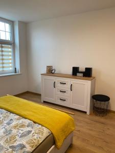 a bedroom with a bed with a yellow blanket on it at City Lights Apartment in Barlinek