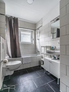 un bagno con un water, una vasca e un lavandino di Voll ausgestattete Apartments mit Einzelbetten - Küche - WLAN - PKW-Parkplatz a Rödermark