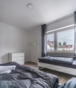 una camera da letto con due letti e una grande finestra di Voll ausgestattete Apartments mit Einzelbetten - Küche - WLAN - PKW-Parkplatz a Rödermark Altre 64 foto