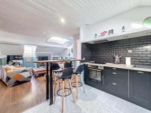 une cuisine avec des armoires noires et une table avec des tabourets dans l'établissement Le Salignat Climatisé, Centre, Proche Thermes, à Vichy 10 autres photos