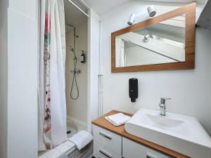 une salle de bain avec un lavabo et un miroir dans l'établissement Le Salignat Climatisé, Centre, Proche Thermes, à Vichy
